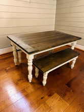 Load image into Gallery viewer, Low angled room view of dark walnut farmhouse table and bench showing the wood-grain tops and white turned legs